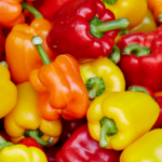 Bunte Paprikafrüchte in Rot, Orange und Gelb — Paprika profitiert besonders vom Kalium im Kartoffelschalenmehl von Kartoffelkraft